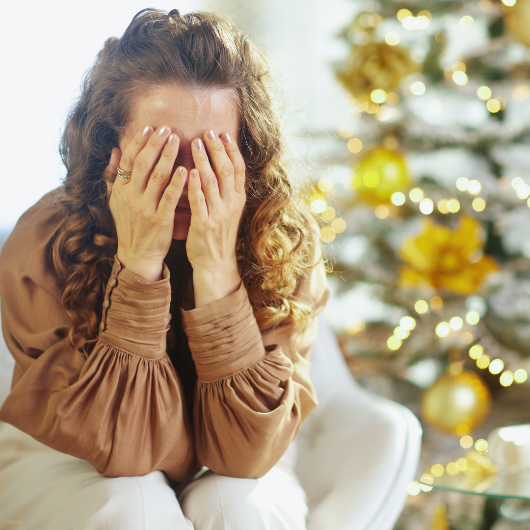 Woman grieving during the holiday season, symbolizing the emotional weight of loss at Christmas.